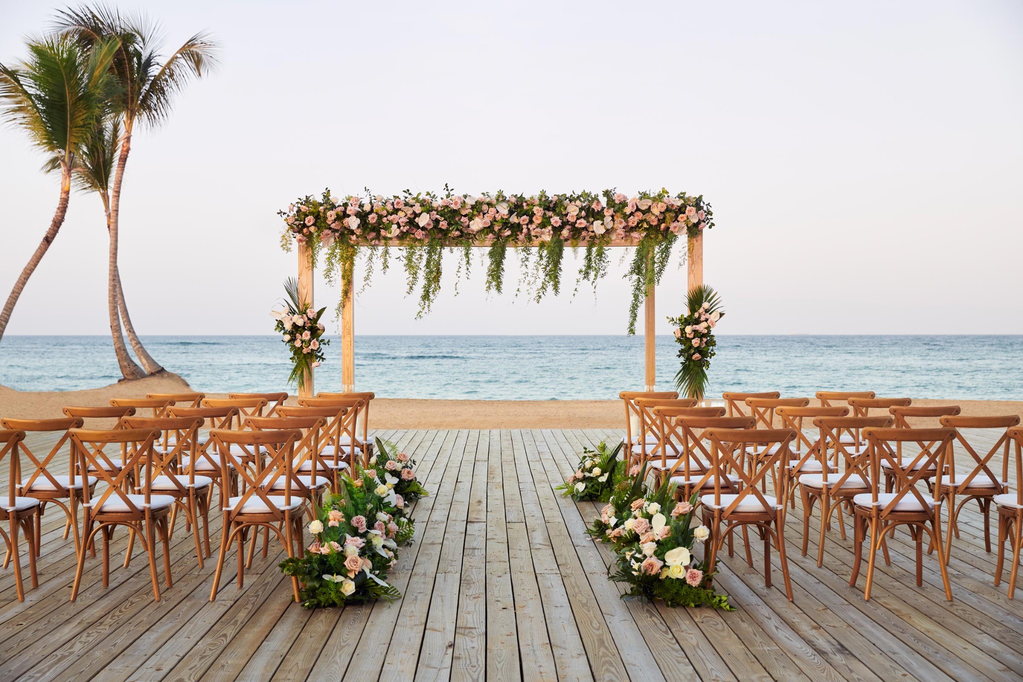 Beach wedding ceremony setup in Punta Cana with tropical floral decorations